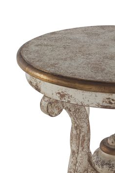 an old white table with gold trimmings and a round wooden top, against a white background