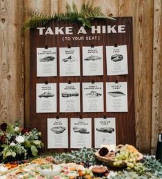 a table topped with lots of food next to a wooden sign that says take a hike