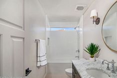 a bathroom with white walls and marble counter tops