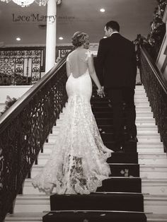 a bride and groom walking down the stairs at their wedding reception in black and white