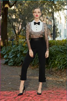 a woman in black and white is posing for the camera with her hands on her hips