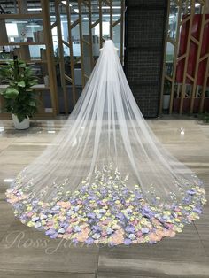 a wedding veil with flowers on the floor in front of an entrance to a building