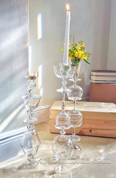 there is a tall glass candle holder on the table