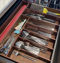 an open drawer filled with silverware and utensils