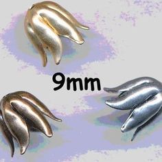 three different sized metal dolphins on a white background