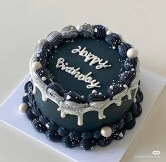 a black and white birthday cake with the words happy birthday written in frosting on it