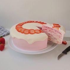 a cake with strawberries on it and a knife next to it