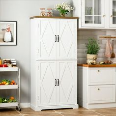 a kitchen with white cabinets and tile flooring