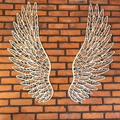 two white metal wings on a brick wall