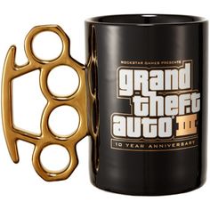 a black coffee mug with gold scissors on it's side and the words grand theft auto