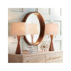 two lamps sitting on top of a wooden dresser next to a mirror and lamp shade