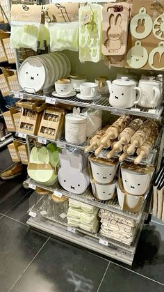 the shelves are filled with dishes, cups and other kitchen items for sale in a store