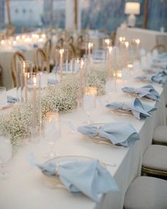 the table is set with candles, flowers and napkins for an elegant wedding reception