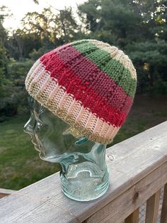 a knitted hat sitting on top of a glass head