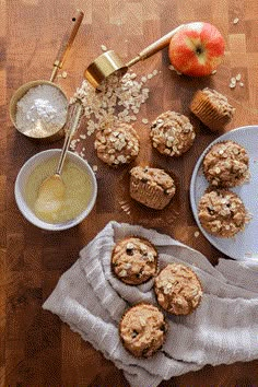 muffins on a table with apples and oatmeal next to them