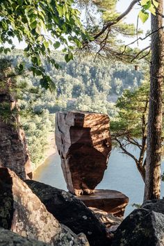 a large rock sitting in the middle of a forest