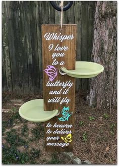 a wooden sign that says whispers i love you to butterfly and fly with two plates on it