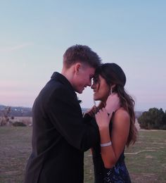 a man and woman standing next to each other in a field