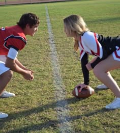 a couple of people that are standing in the grass with a football on their feet