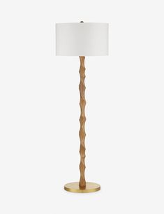 a wooden floor lamp with a white shade on the base and a gold plated metal base