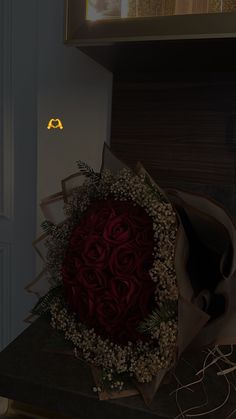 a bouquet of red roses sitting on top of a counter next to a mirror and door