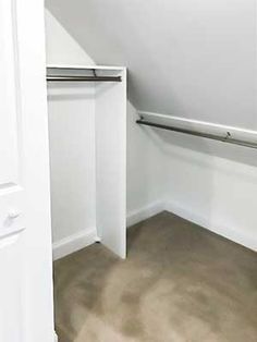 an empty closet with white walls and carpet