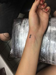 a woman with a small tattoo on her arm holding a roll of tinfoil wrapped in foil