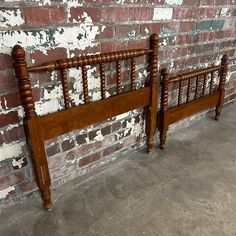 an old wooden bed frame against a brick wall