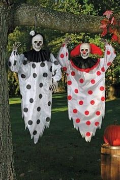 two halloween decorations hanging from a tree