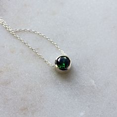 A deep green cubic zirconia, beautifully faceted for maximum sparkle, is set entirely in sterling silver in this versatile necklace, perfect for layering. A slim but sturdy sterling silver chain slides freely through the setting, and the necklace is finished with a simple spring ring clasp. The round faceted emerald CZ measures 6mm in diameter. Choose your perfect necklace (measured end-to-end including clasp) length from the drop-down menu. The last photo shows the same size gemstone and settin Faceted Sterling Silver Birthstone Necklace With Round Pendant, Green Sterling Silver Birthstone Necklace With Round Pendant, Minimalist Sterling Silver Emerald Necklace For May Birthstone, Green Sterling Silver Birthstone Pendant Necklace, Sterling Silver Necklace For May Birthstone, Green Pendant Birthstone Necklace In Sterling Silver, Green Sterling Silver Pendant Birthstone Necklace, Green Solitaire Necklace For May Birthstone Gift, Minimalist Green Emerald Necklace In Sterling Silver