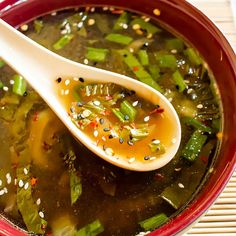 a spoon full of soup with green beans and sesame seeds