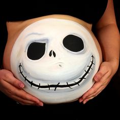 a pregnant woman with her belly painted to look like jack skellingy - face