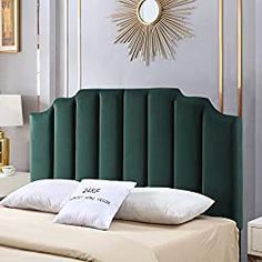 a green headboard with two pillows on it and a gold starburst above the bed