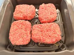 four hamburger patties are in the air fryer