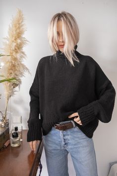 "Stylish chunky turtleneck sweater with long sleeves and shorter front made in black. Materials: wool blend (wool/acrylic) Size: S/M Measurements: Length: front 20.5\" = 52 cm back 25.5\" = 65 cm Chest: 29\" = 74 cm Measures of Model in the photo Size: S Chest: 32\" - 82 cm Waist: 24\" - 62 сm Hip: 34\" - 88 cm Height: 66\" - 170 cm CARE INSTRUCTIONS: DRY CLEAN is the best way. HAND WASH. Make sure to use cold water and neutral soap. The less you touch and agitate them, the better. Do not press. MASHINE WASH. Please use only cold water and gentle (hand) cycle. Do not use tumble dry. FLAT DRY - reshape the garment to it's original shape. KEEP FLAT only. Do not hang! You can message me and get some additional measures and photos of the garment. This item is handmade, so you will not receive Black Turtleneck Cropped Sweater For Fall, Oversized Black Turtleneck For Fall, Black Soft Knit Turtleneck Sweater, Cozy Black Turtleneck For Fall, Black Chunky Knit Turtleneck Sweater, Black Knitted High Neck Turtleneck, Black Chunky Knit High Neck Sweater, Black Wool Sweater With Chunky Knit, Black Wool Chunky Knit Sweater