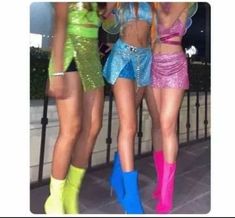 three women in short shorts and boots standing next to each other