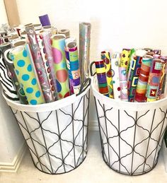 two white buckets filled with different types of pens and pencils next to each other