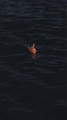 a person floating in the water with their hand up