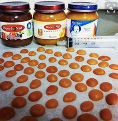 three jars of peanut butter sitting on top of a table next to a measuring tape