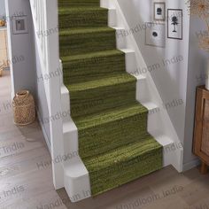 a green carpeted staircase with white handrails