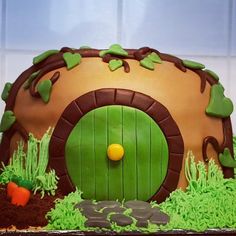 a cake that looks like a hobb door with grass and carrots on it