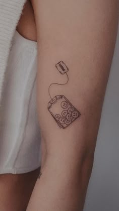 a woman's arm with a tattoo on it that has a coffee cup in the middle