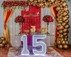 the table is decorated with flowers, candles and balloons in front of an arch that reads fifteen five