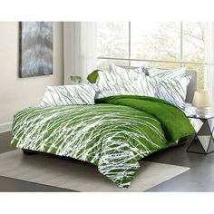 a bed with green and white comforters in a room