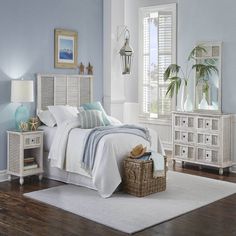 a bedroom with blue walls and white furniture