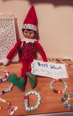 an elf is sitting on top of a table with beads and bracelets around it