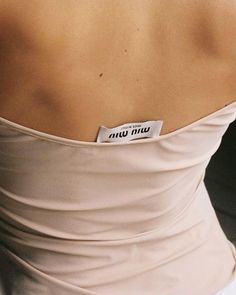 the back of a woman's dress with a name tag attached to her chest