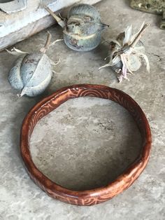 This bracelet will remind you of an ancient relic! However, it has a very glossy sheen. The depth of color and tones are amazing. All sides are glazed. This handmade bracelet was made by me in my studio. Beginning with raw clay, the bracelet was formed, dried slowly, fired in a kiln to 1800 degrees Fahrenheit, dipped in glaze, and then fired again to over 2300 degrees Fahrenheit. This bracelet is 2.5 inches across in the center opening, and because it is closed, be sure to measure one of your cu Brown Carved Bracelet Jewelry, Artisan Hand Cast Bangle Bracelet, Artisan Hand Cast Bangle Bracelets, Handmade Leather Bangle Bracelet, Artisan Electroformed Bangle Bracelets, Patina Brown Bracelet Jewelry, Unique Brown Bracelet With Patina, Bohemian Carved Bangle Bracelet, Brown Patina Bracelet Jewelry