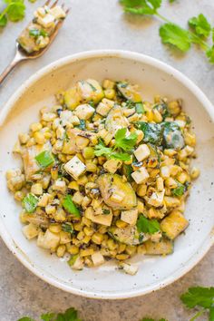 a white bowl filled with corn and herbs