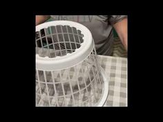 a man is working on an item that looks like a wire basket with holes in it